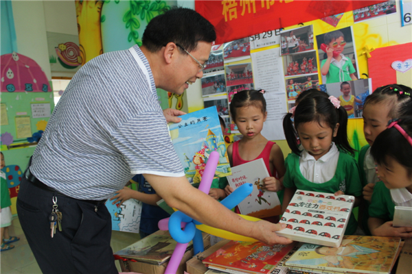 梧州市總工會黨組書記、常務(wù)副主席朱明勝在梧州市總工會到梧州高新區(qū)雙語實驗學校開展關(guān)愛農(nóng)民工留守活動中為孩子們送上學習用具